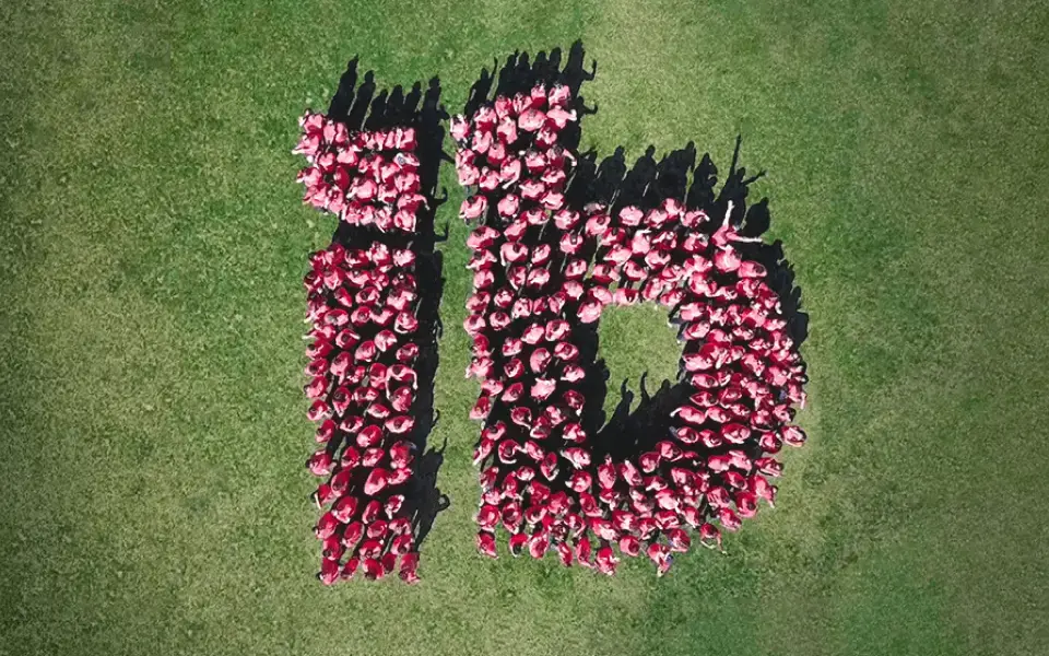 Ibotta employees forming the Ibotta logo on grass
